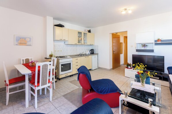 Un appartement moderne comprenant un coin repas, une cuisine, un salon et un téléviseur.