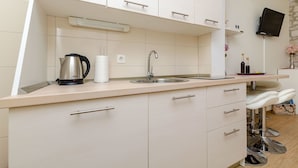Una cocina moderna con un lavamanos, hervidor y encimera.