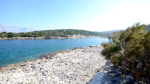 Una costa rocosa con vista despejada a un lago tranquilo y montañas distantes.