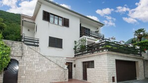 Uma casa de dois andares com garagem, varanda e escada que leva ao andar superior.
