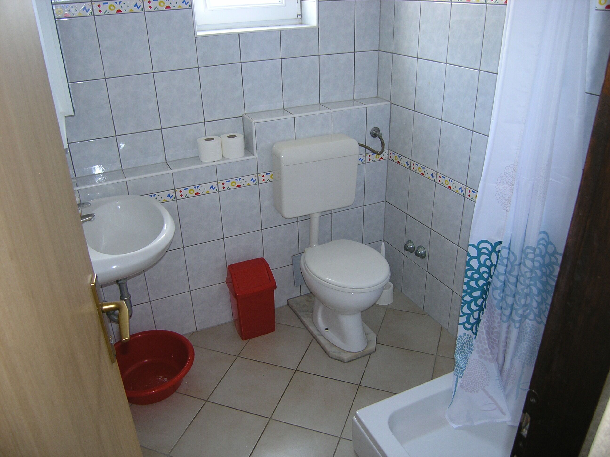 Ein kleines Badezimmer mit Toilette, Waschbecken und Dusche.