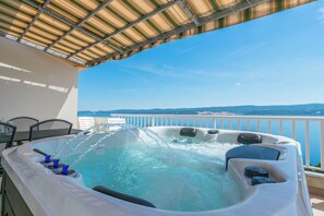 Ein Whirlpool mit Düsen, ein Tisch mit Stühlen und Meerblick.