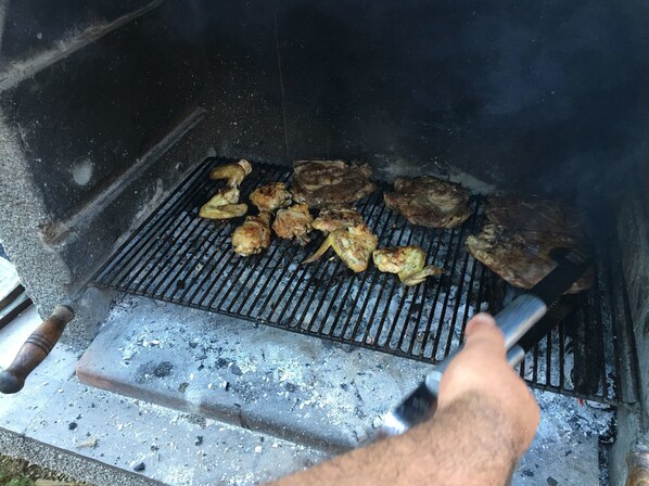En grill med forskellige kødretter under tilberedning.