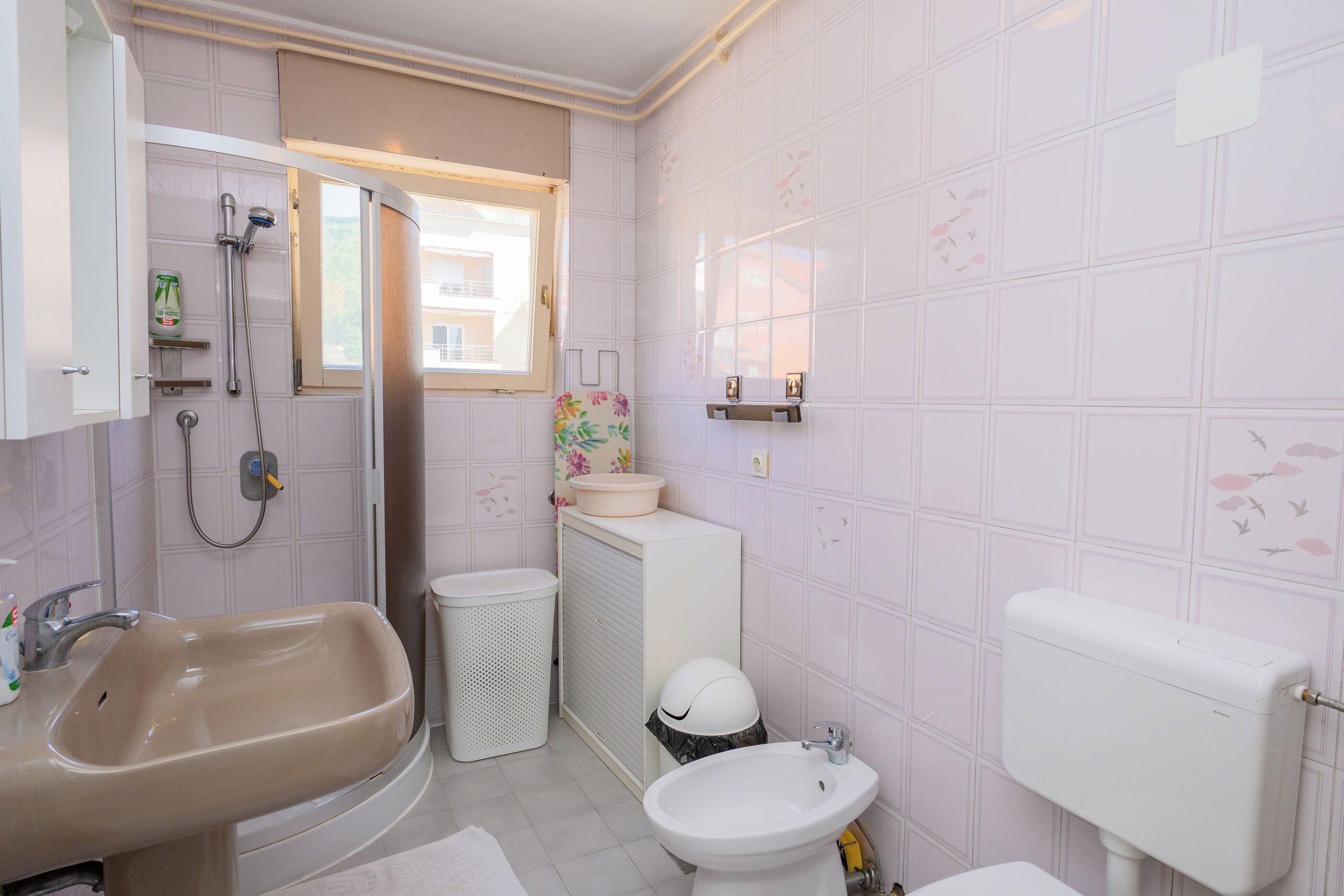 A bathroom with a bathtub, a sink, a toilet, and a window.