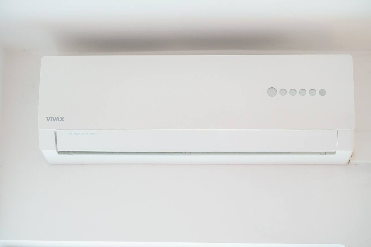 Eine weiße Klimaanlage mit dem Markennamen 'VIVAX' und einer Bedieneinheit mit fünf Tasten.