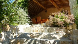 A stone staircase leading to a wooden deck with outdoor furniture. - L'Estuve Provençale (Bargemon)
