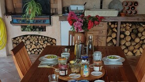 A wooden dining table set with various dishes, including bread, cheese, and a salad. - L'Estuve Provençale (Bargemon)