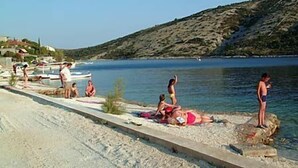 Ein Strand mit badenden und sonnenbadenden Personen.