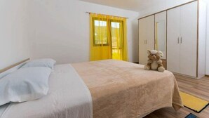Ein Schlafzimmer mit Bett, Kleiderschrank und Stofftier.