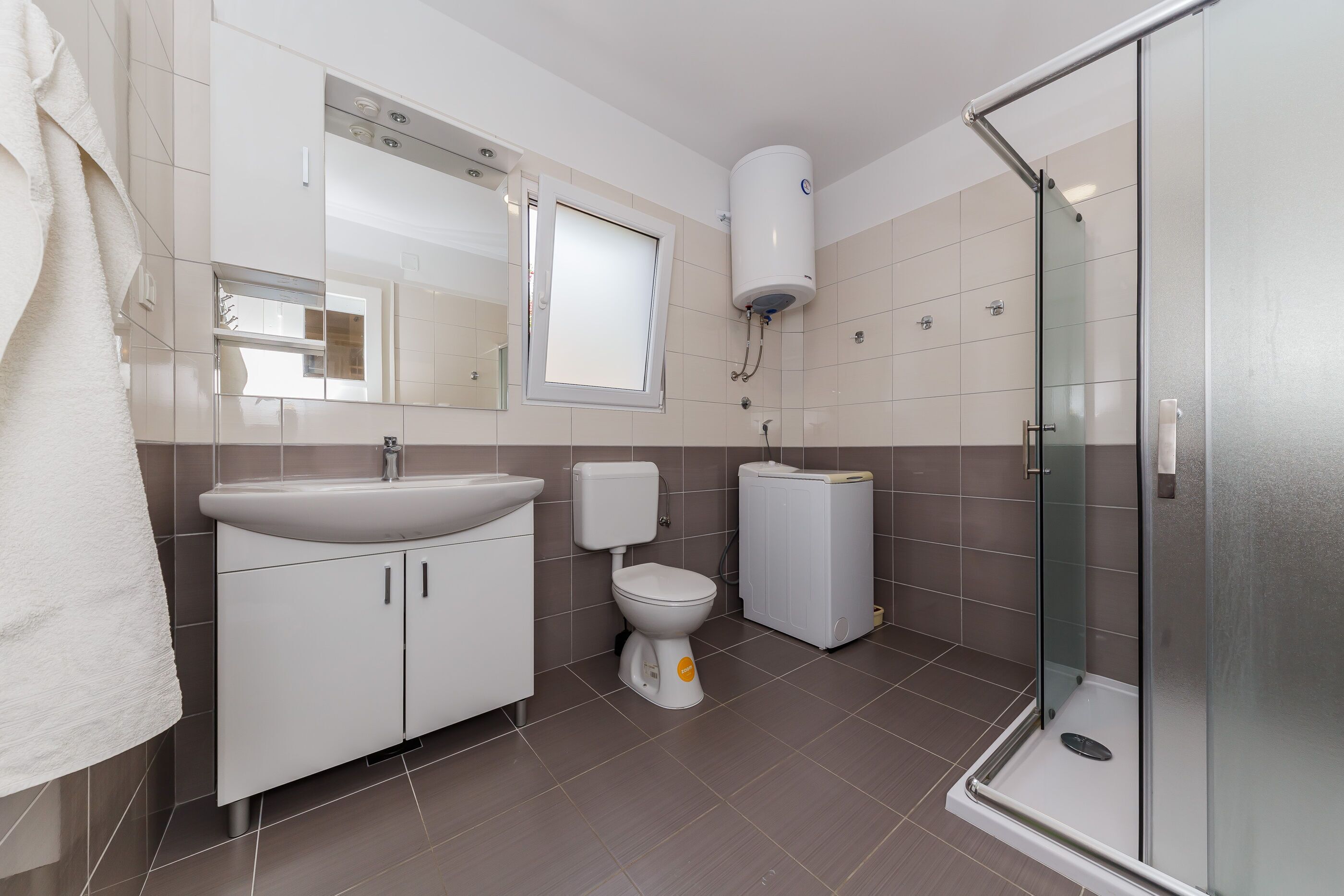 A modern bathroom with a sink, toilet, and shower.