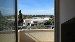 Ein Balkon mit Blick auf ein Bürogebäude und ein Gewässer.