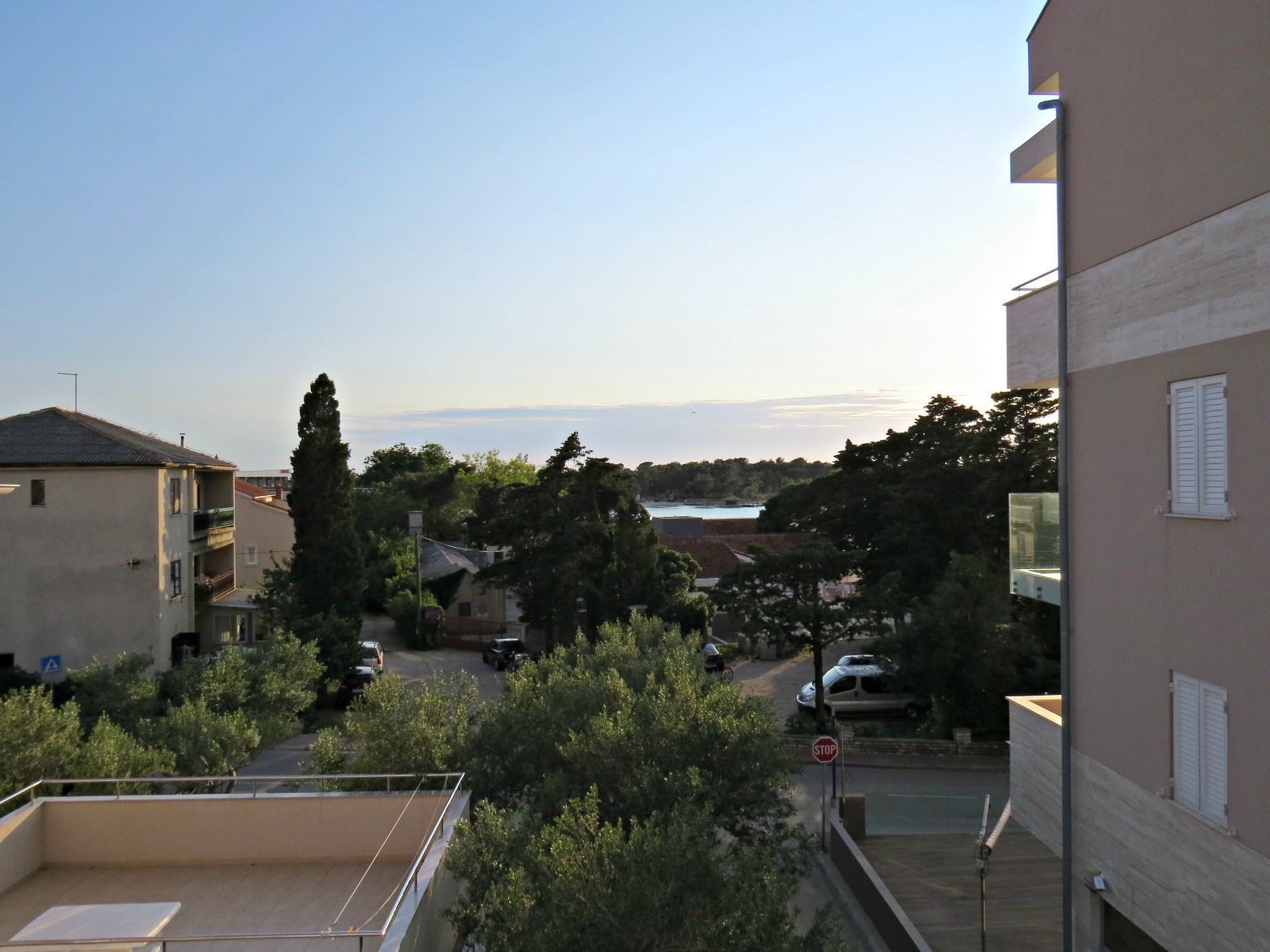 Zona residencial con edificios, árboles y una señal de parada.