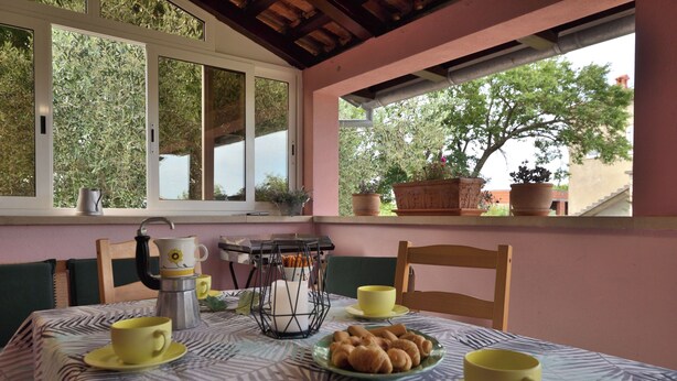 A dining area with a table set for two, featuring a coffee maker, cups, and pastries. - House Marlu (Rakalj)