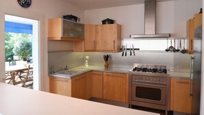 A modern kitchen with wooden cabinets, a gas stove, and a built-in oven. - exceptional, quiet, golf on 27 holes character villa, heated pool (Biscarrosse)