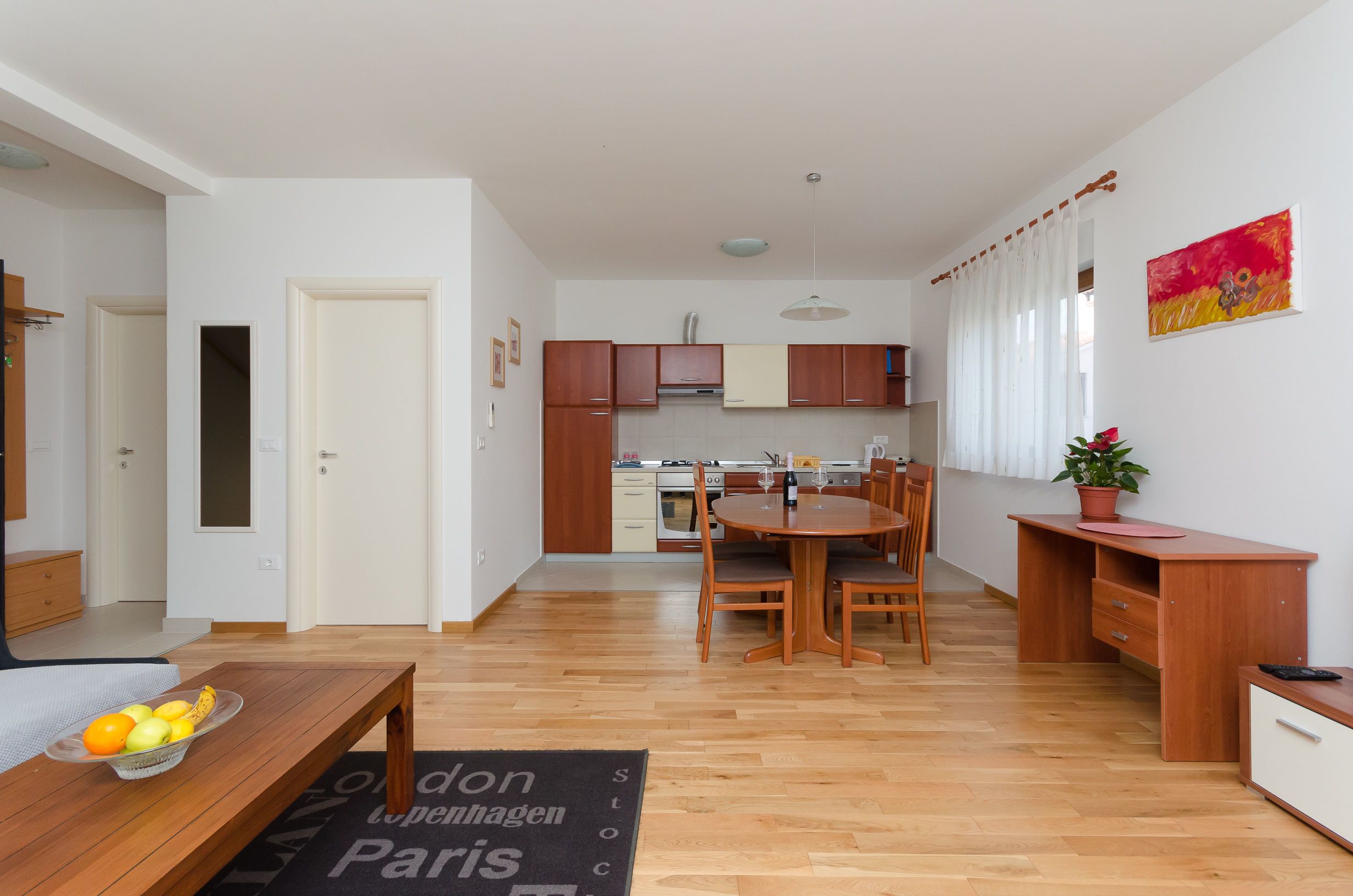 A modern apartment with a dining area, kitchen, and a living room.