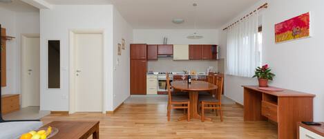 A modern apartment with a dining area, kitchen, and a living room.