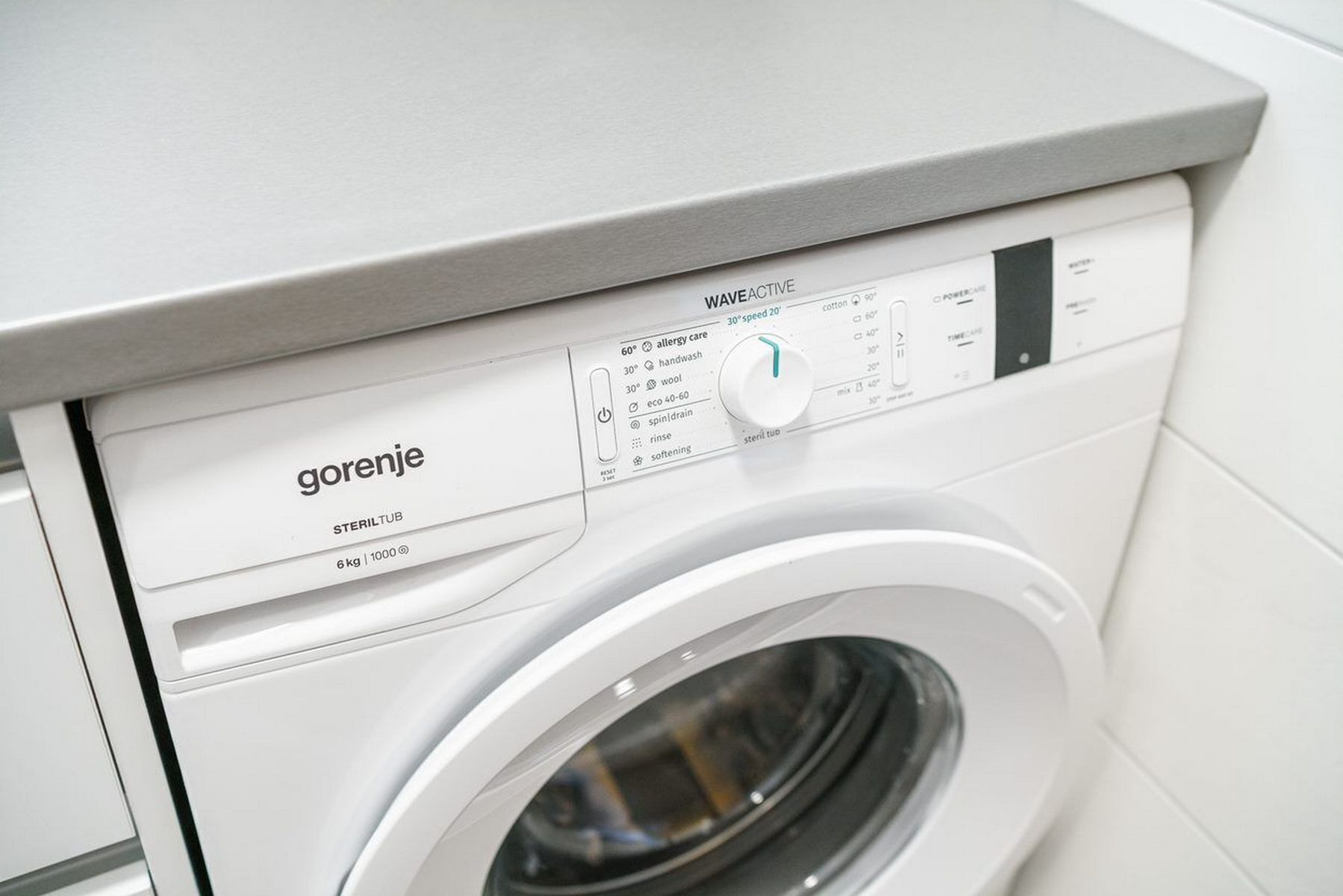 Eine Frontansicht einer weißen Waschmaschine mit einer Bedieneinheit, auf der 'Gorenje' und 'STERILTUB 6 kg | 1000' steht.