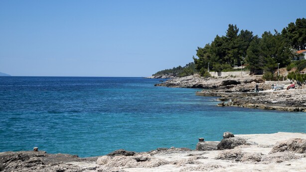 A coastal landscape with rocky terrain and clear blue sea. - Apartments Tonin (Ivan Dolac)