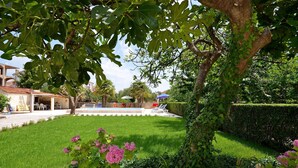 A well-maintained garden with a swimming pool, neatly trimmed hedges, and a variety of plants. - Apartments Vesna With Pool (Vodice)