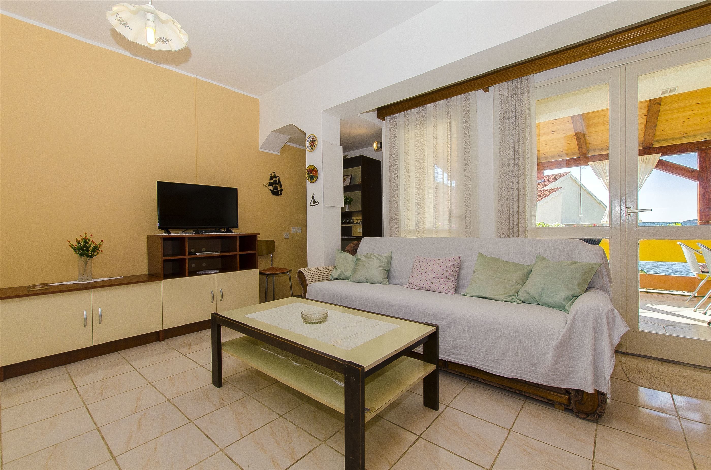 Una sala de estar con un sofá, televisor y una mesa de centro.