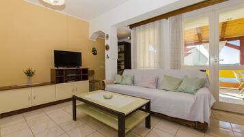 Una sala de estar con un sofá, televisor y una mesa de centro.