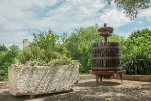 A garden with a large planter and a rustic water feature.