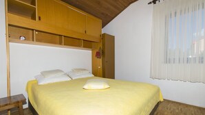 Una camera da letto con un letto, un'armadiatura in legno e una finestra con tende.