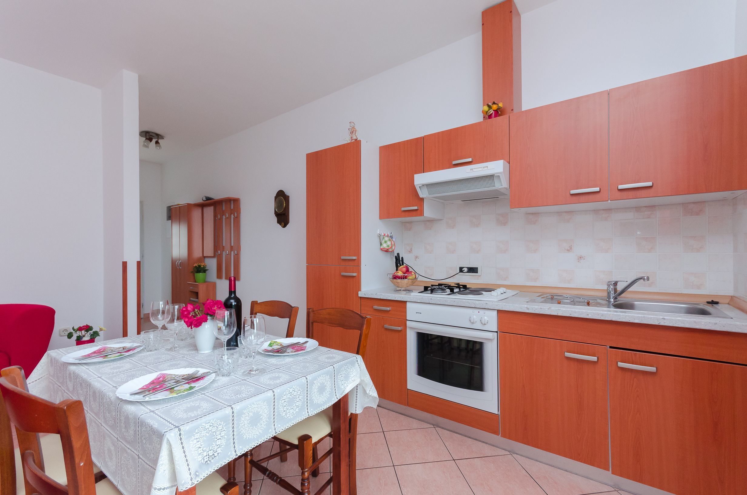 A compact kitchen with wooden cabinets, a gas stove, and a sink.