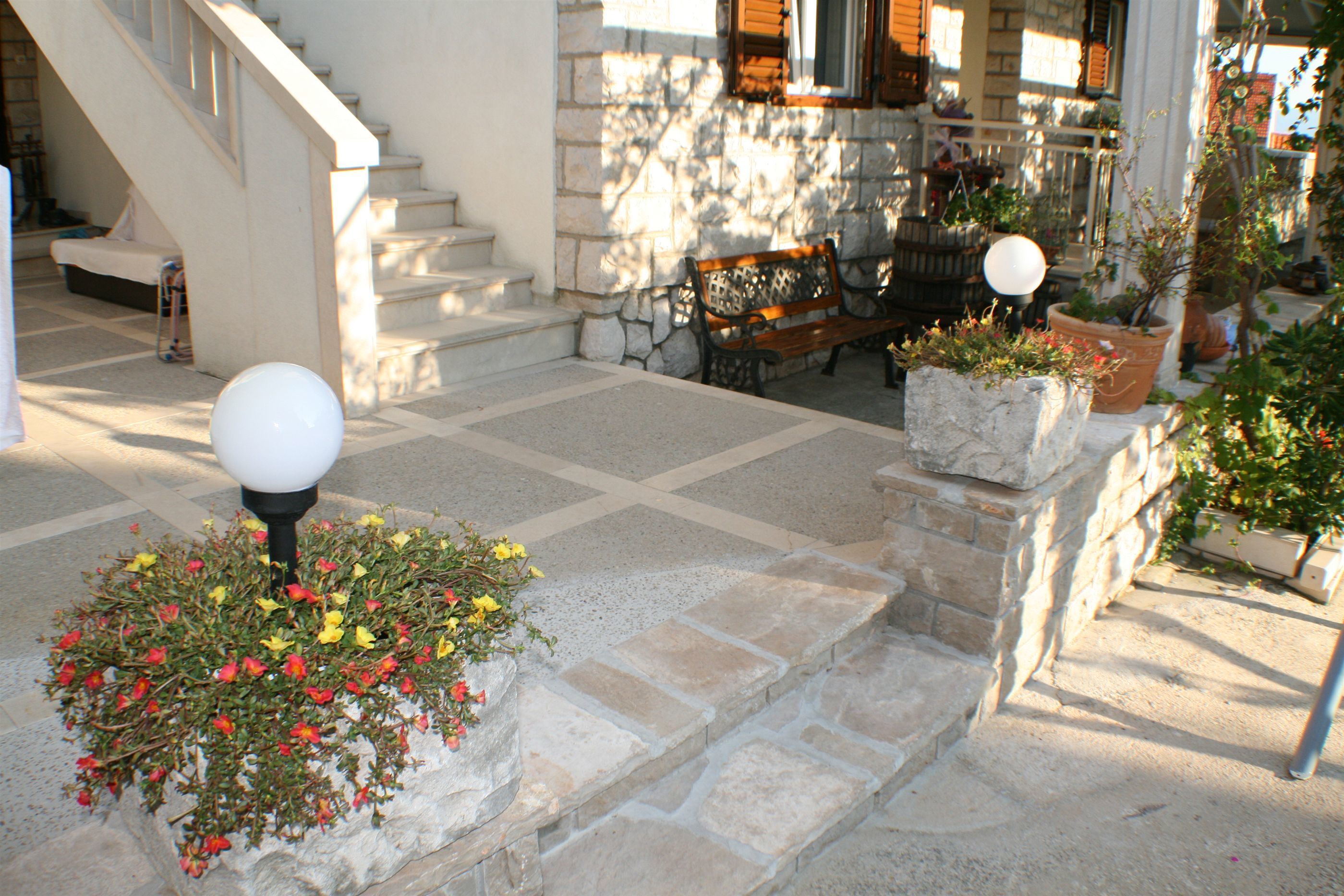 A stone staircase leading to a wooden bench and a light fixture.