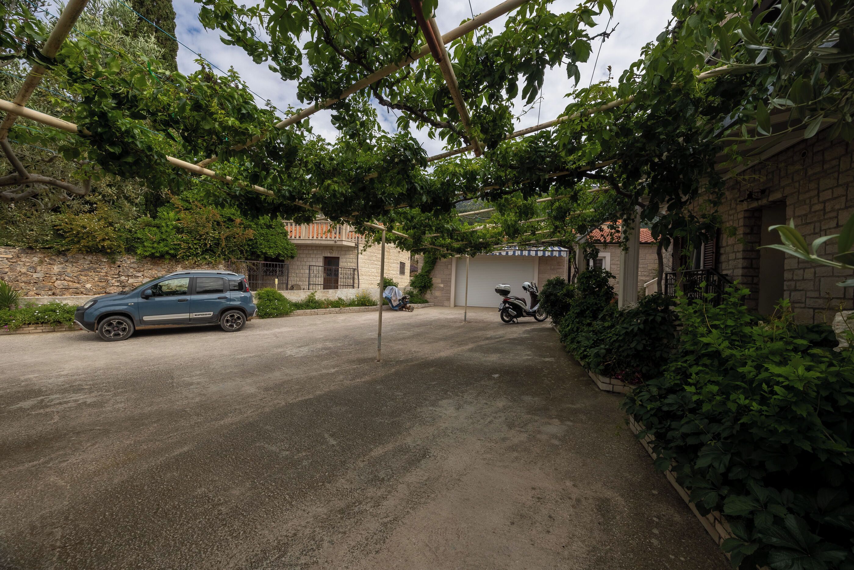 Ein gepflasterter Weg führt zu einem Gebäude mit Garage.