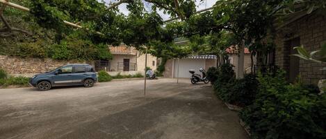 Ein gepflasterter Weg führt zu einem Gebäude mit Garage.