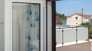 A room with a view of a hillside and buildings. - Apartments Hrvatic (Rogoznica)