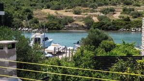A marina with boats docked, surrounded by greenery and hills. - Apartments Hrvatic (Rogoznica)