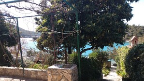 Un banco de piedra con vistas a un cuerpo de agua y un edificio al fondo.