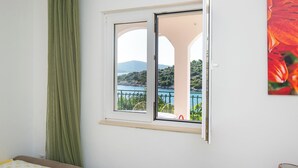Una habitación con ventana que ofrece una vista panorámica de un lago y colinas.