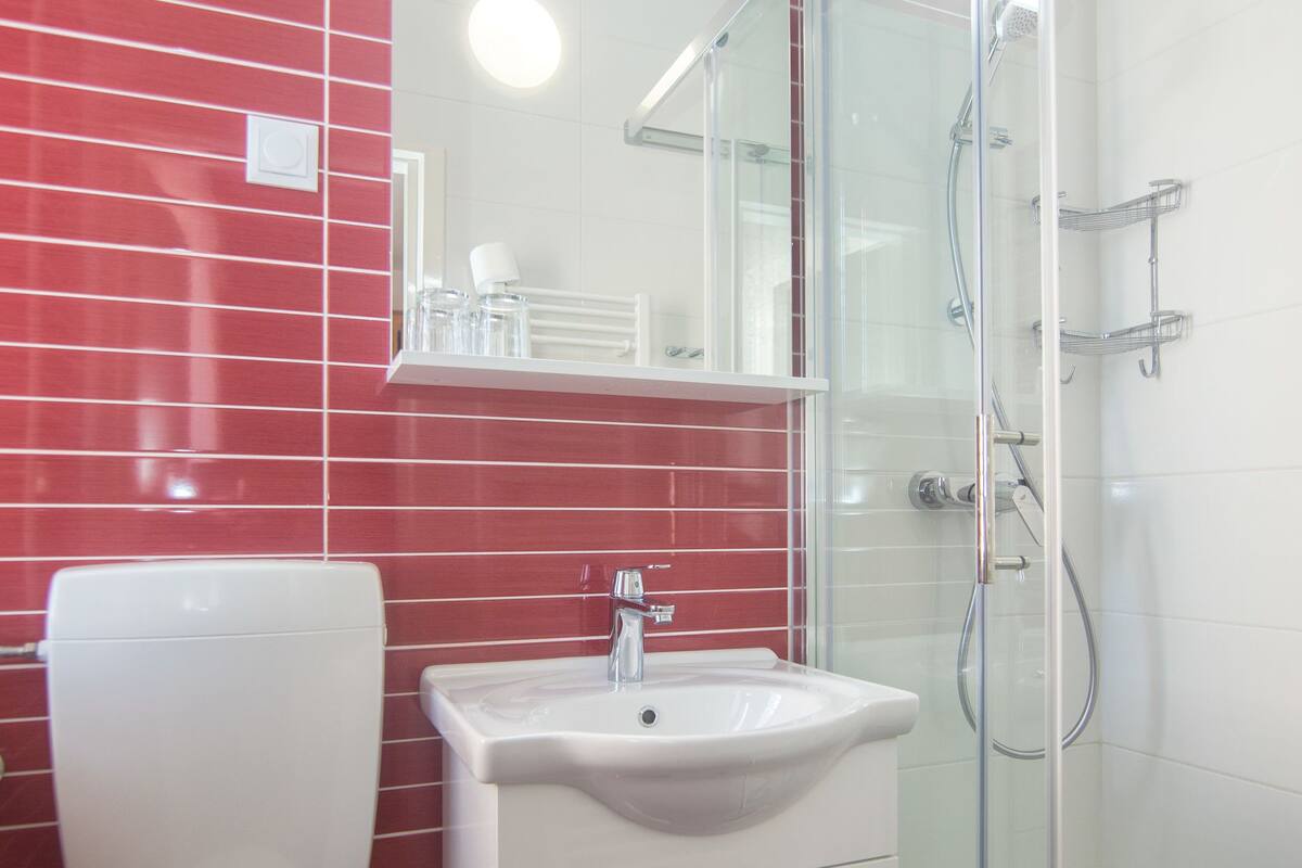 Un baño con inodoro, lavamanos y cabina de ducha de vidrio.