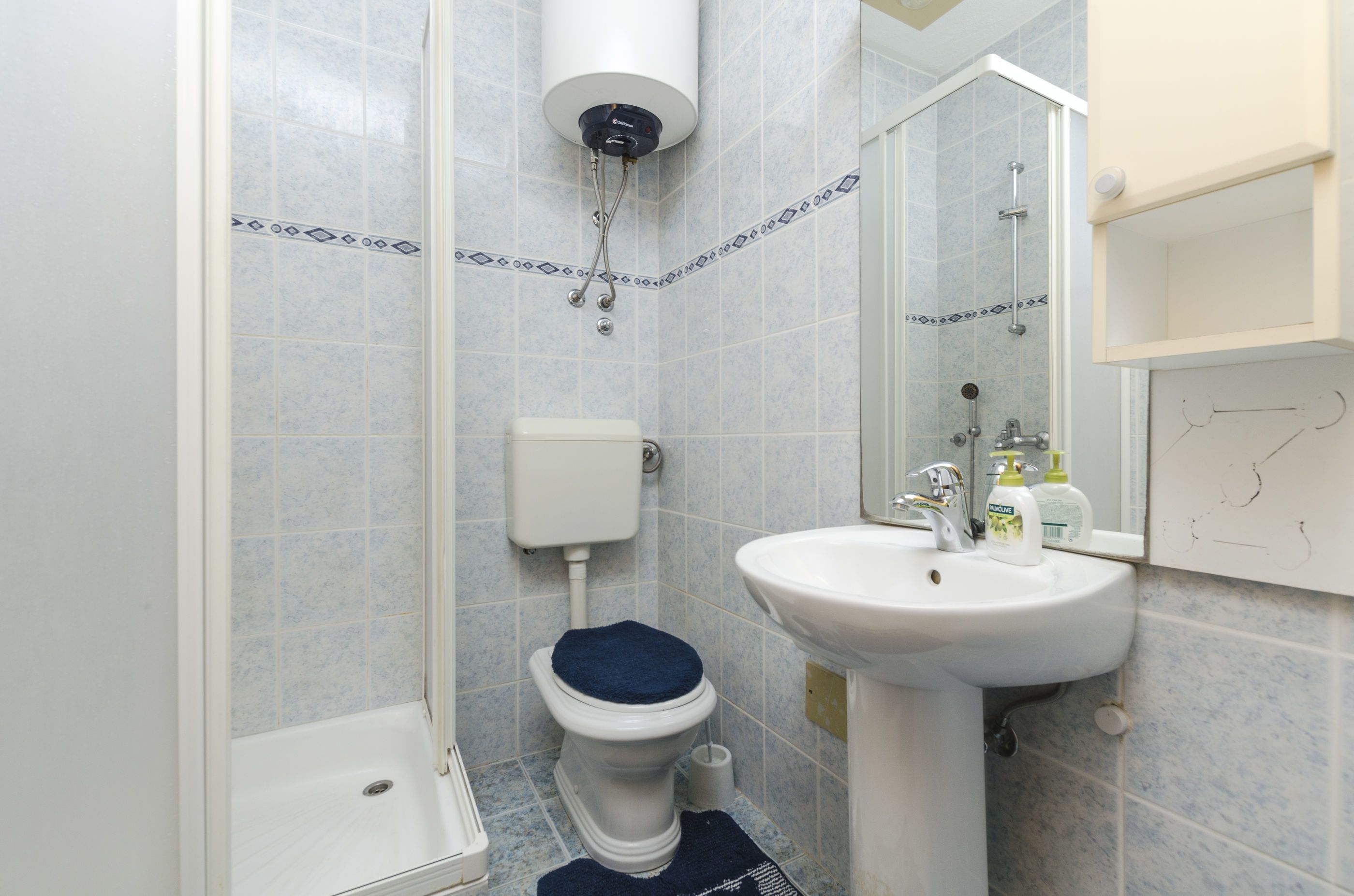 A bathroom with a toilet, sink, and shower.