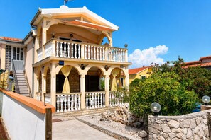 A two-story building with a balcony, stone walls, and a clear blue sky. - Apartment Veronika (Razanj)