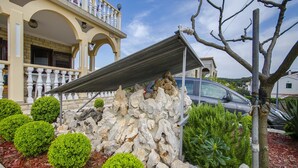 Un edificio con facciata in pietra, un portico coperto e un'auto parcheggiata davanti.
