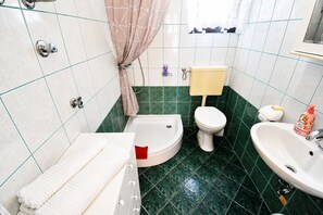 A bathroom with a bathtub, toilet, and sink. - Apartment Veronika (Razanj)