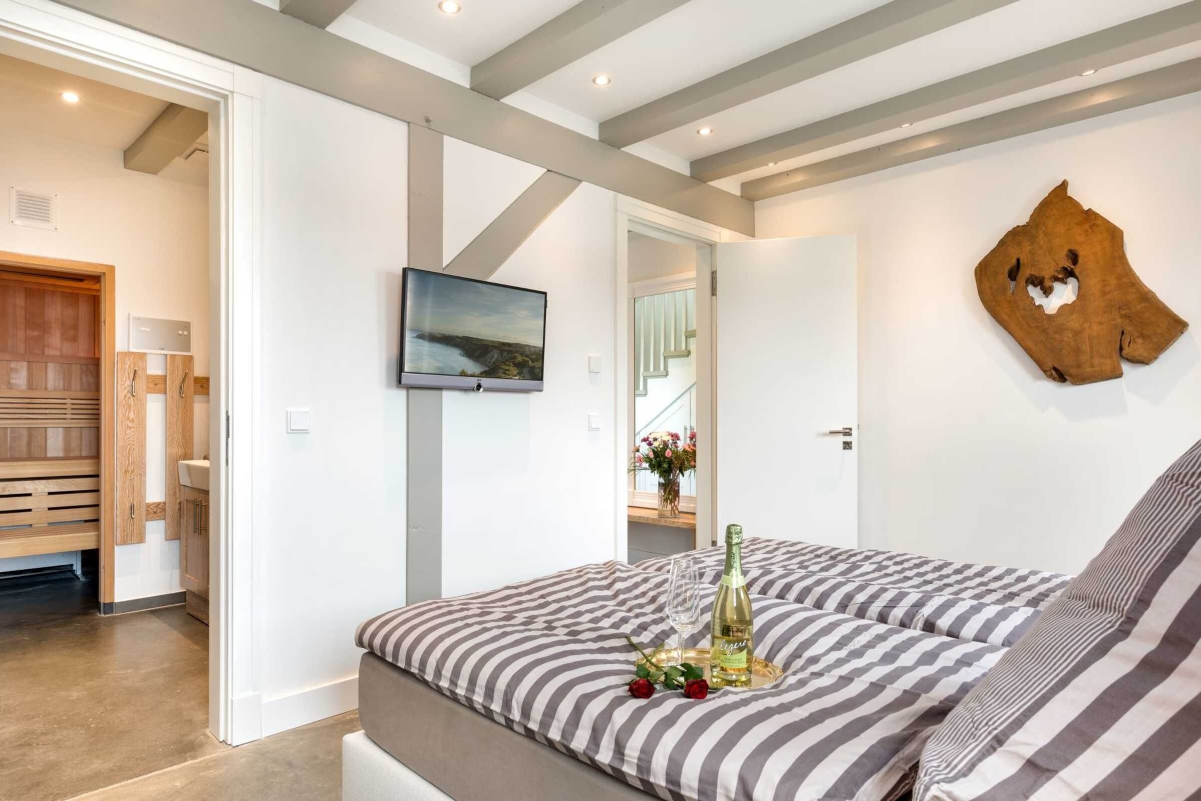 Ein Schlafzimmer mit einem Bett, einem Fernseher und einer Flasche Champagner auf dem Bett.