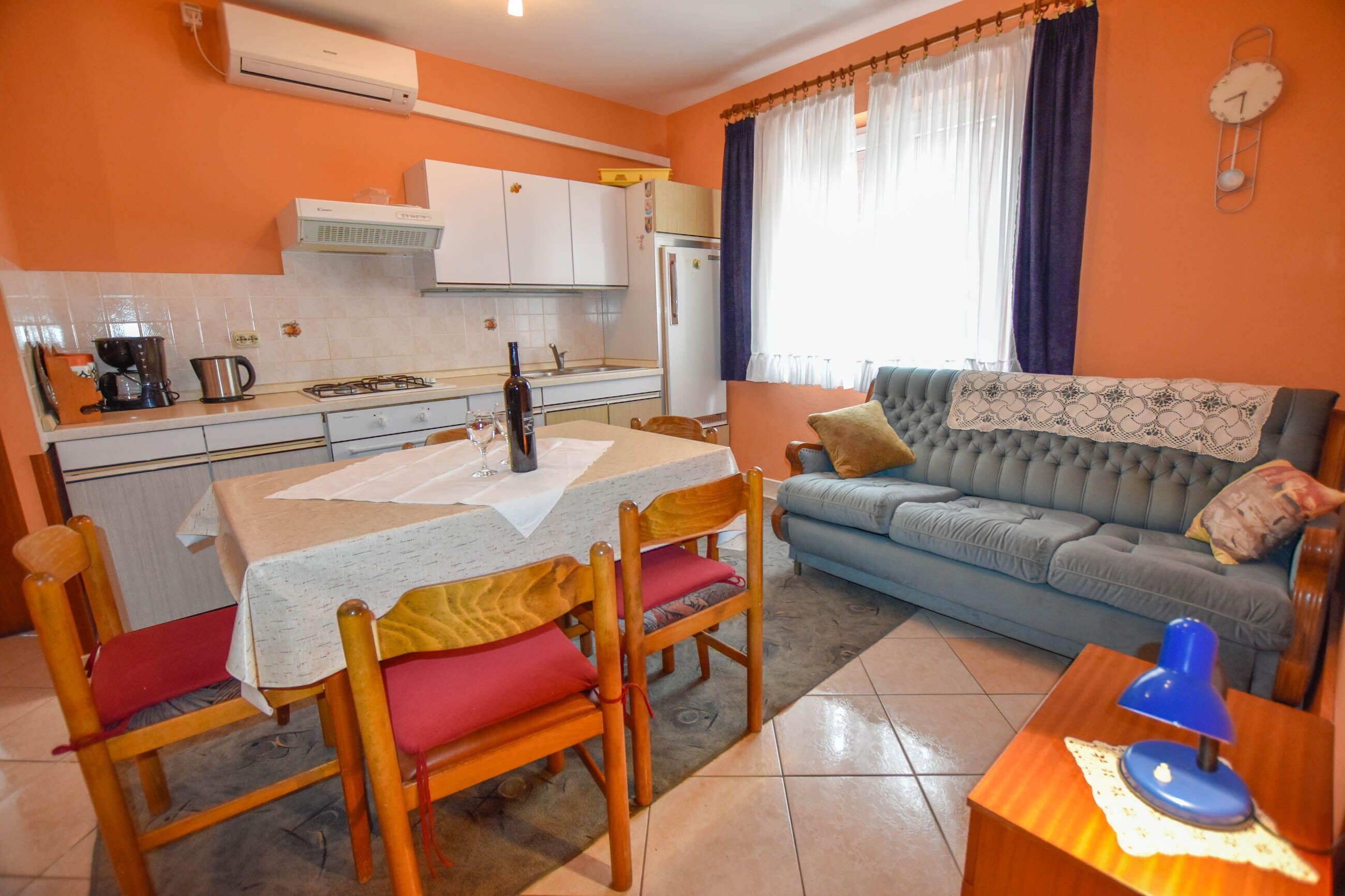 A compact living space with a dining area, kitchen, and a sofa.