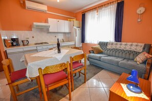 A compact living space with a dining area, kitchenette, and a sofa.