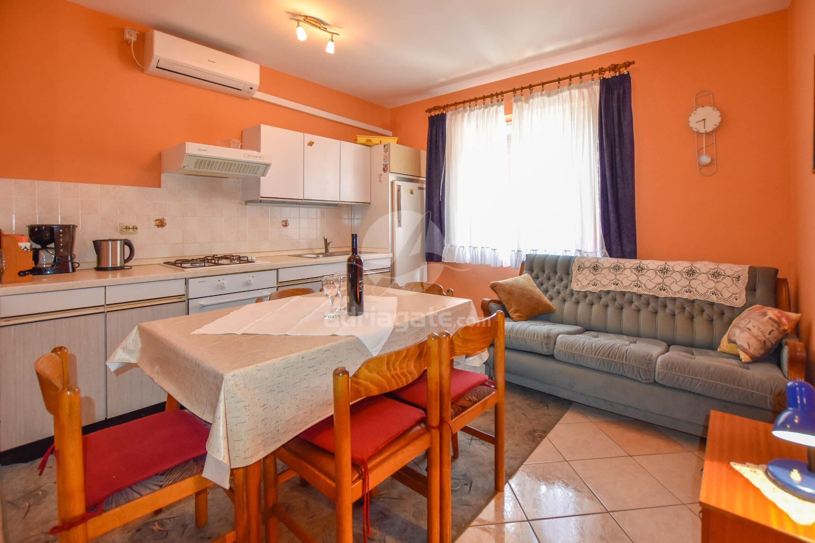 A compact living space with a kitchen, dining area, and a sofa.