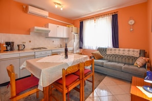 A compact living space with a kitchen, dining area, and a sofa.