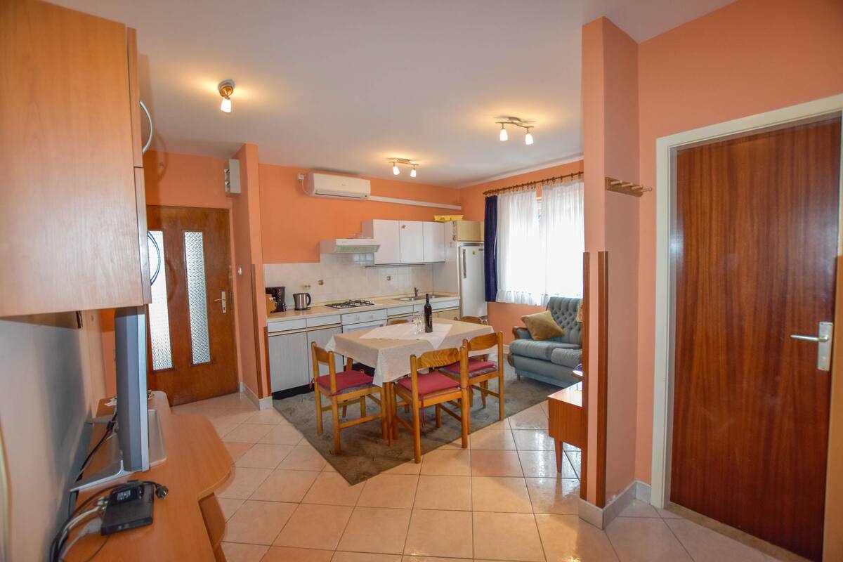 A compact living space with a kitchenette, dining area, and a sofa.