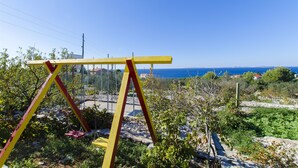 Ένα σετ κούνιας σε έναν κήπο με θέα στη θάλασσα.