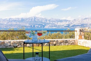 Een terras met een tafel gedekt voor drankjes, met uitzicht op een bergmeer.