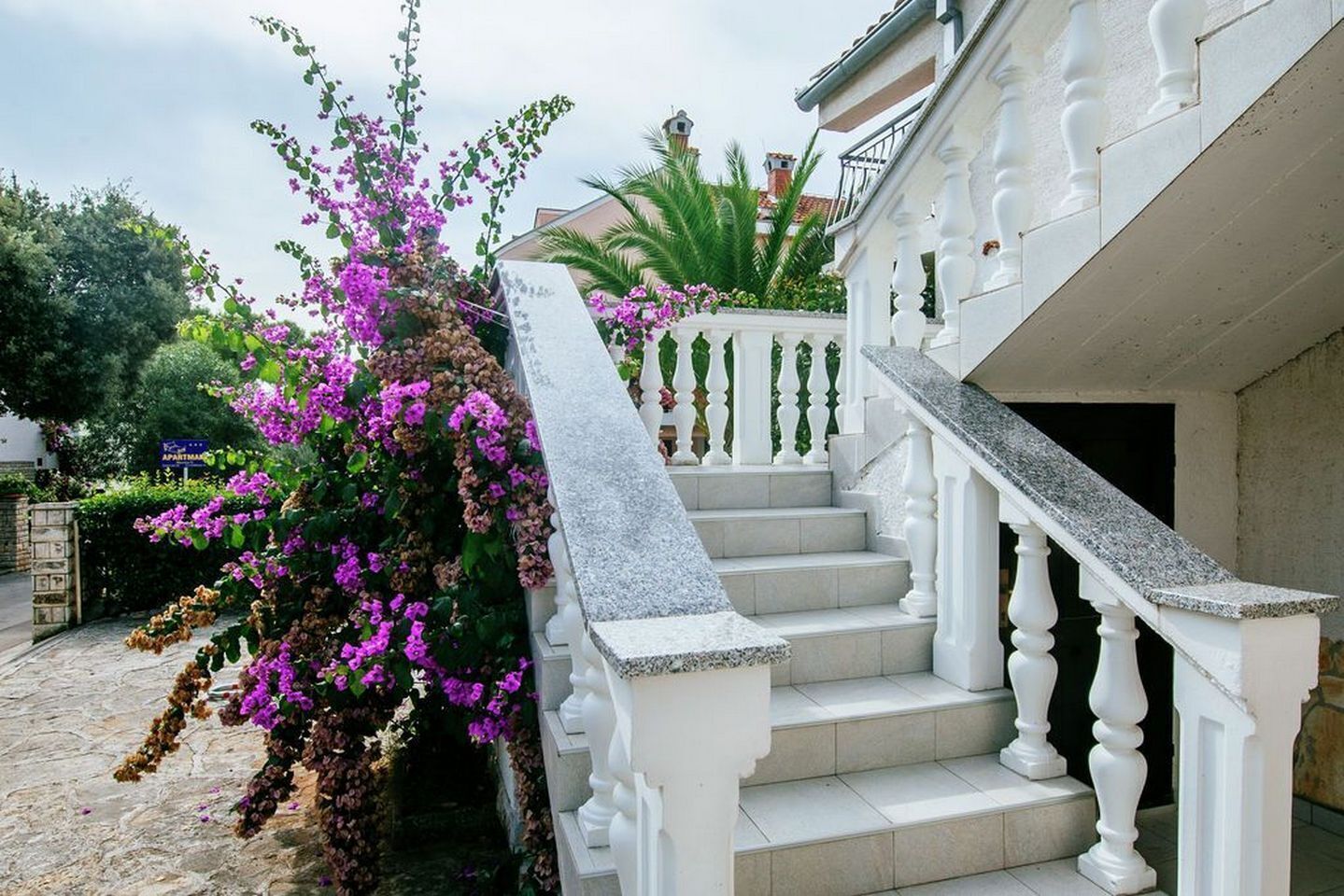 A staircase with white balustrades leading to a building entrance.