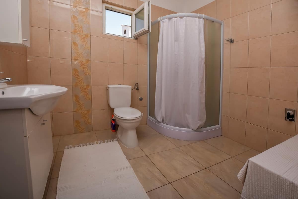Un baño con lavamanos, inodoro y ducha.